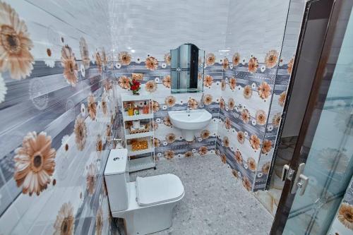 库马西Pomaa Villa的一间带水槽、卫生间和墙壁的浴室