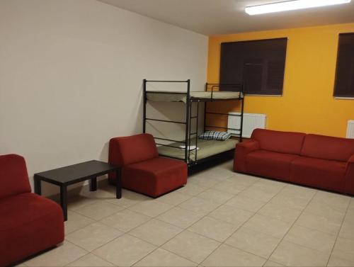 维尔纽斯Centro Hostel的一间设有两张红色椅子和书架的等候室