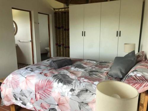 索德瓦纳湾The Rondavel @ Foundation Lodge的一间卧室配有一张带彩色毯子的床