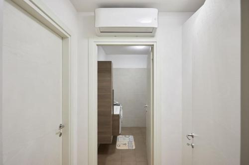 阿维亚诺Center Aviano Comfort Suite FREE PARKING WIFI的走廊上设有通往浴室的门