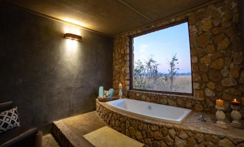 DeteGwango Elephant Lodge的窗户客房内的大浴缸