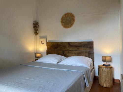 Castello-di-RostinoCasa a Stretta的一间卧室配有一张带白色床单和两盏灯的床。