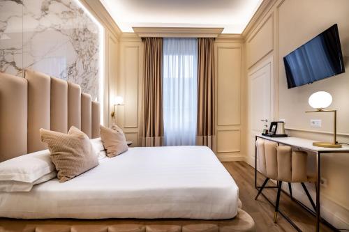 佛罗伦萨Hotel Emma Small Luxury Hotel的配有一张床和一张书桌的酒店客房