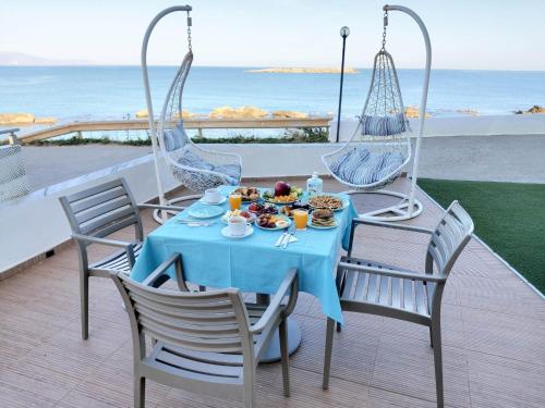 干尼亚克里纳基斯海滩酒店的阳台上配有一张蓝色桌子、椅子和食物