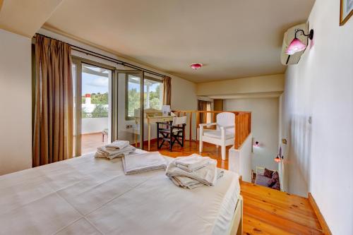 AchladaMourtzanakis Residence - Traditional Eco Hotel in Achlada的一间带一张白色大床的卧室和一间用餐室