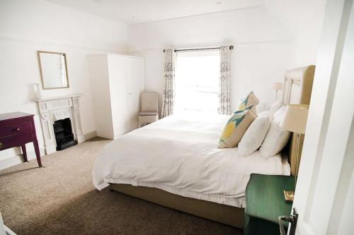 考斯Woodyear House - Cowes - Sleeps 8 - 4 Bed - Dog Friendly - Waterfront的白色的卧室设有床和窗户