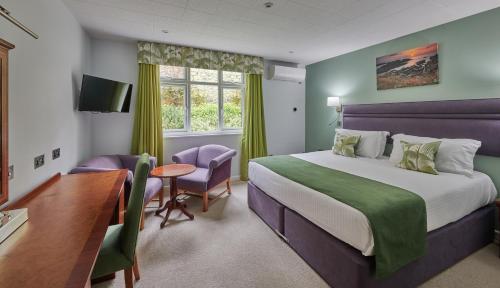 圣彼得港Best Western Moores Central Hotel的配有一张床、一张桌子和一张桌子的酒店客房