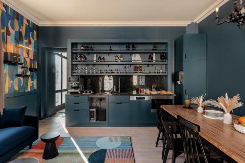 图尔La Loge Gogaille - Corneille - Accès autonome的厨房设有蓝色的墙壁和木桌