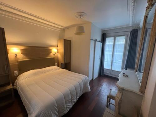 巴黎凯尔特人酒店的卧室设有白色的床和大窗户