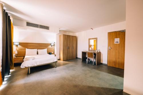 圣保罗湾城普利梅拉酒店的配有一张床和一张书桌的酒店客房