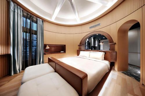 上海上海外滩沙美大楼ZHotel的一间卧室配有一张床和一张沙发