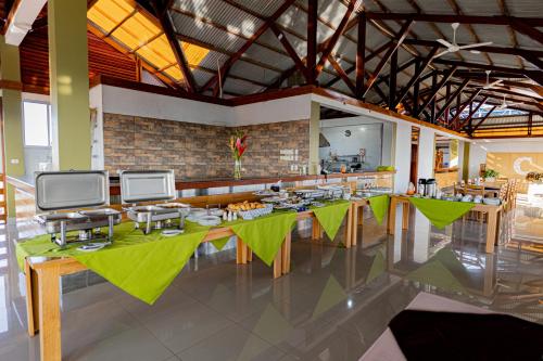 马尔多纳多港Copasu Hotel的餐厅设有一张带绿桌的长桌