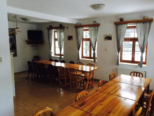 约瑟夫杜尔Chata Čert的用餐室设有木桌、椅子和窗户。