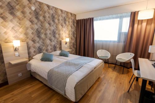卡里纳齐维塔斯库酒店的酒店客房带一张床、一张桌子和椅子