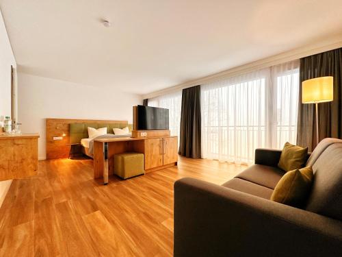 海瑞星阿莫斯Seespitz Gästehaus的客厅配有沙发和带电视的桌子