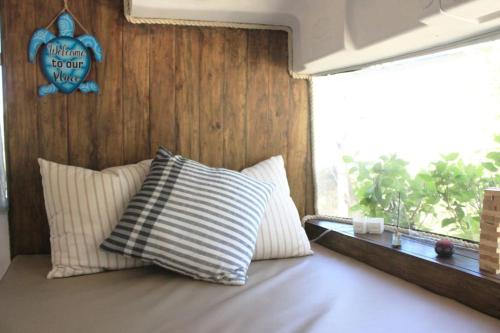 Veintisiete de AbrilCasa Bus los Guanacastes的窗户间内的一张带两个枕头的床