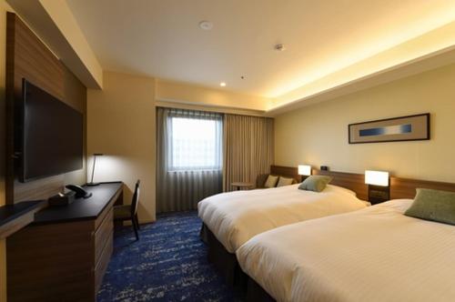 宫崎宫崎市酒店的酒店客房设有两张床和一台平面电视。