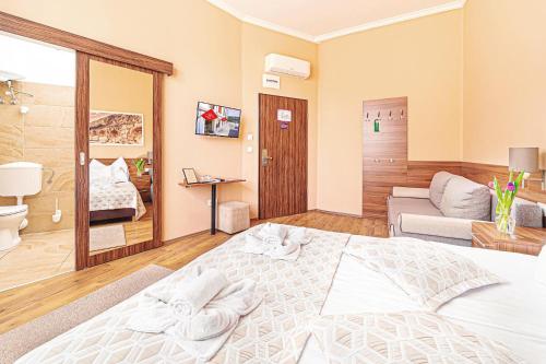 松博特海伊Forum Hotel的卧室配有一张白色的大床和一张沙发。