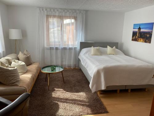 奥贝里德Schwarzwaldglück Apartment的白色卧室配有床和沙发