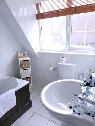 本布里奇The Birdham At Bembridge的白色的浴室设有水槽和卫生间。