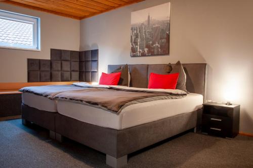 Wimpassing移动客房酒店的一间卧室配有一张带红色枕头的大床