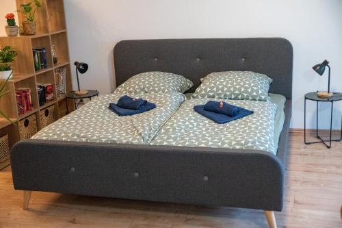 柏林Zuhause fühlen in Kreuzberg的一张黑色的床,上面有两个蓝色的枕头