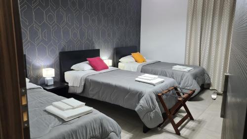 莫塔·圣塔纳斯塔西亚Idilliaco inn的一间设有三张床的客房,备有毛巾