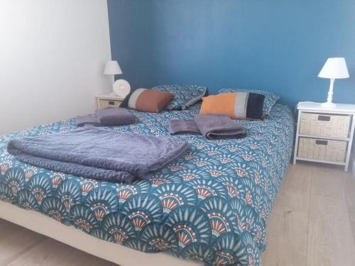 Hauteville-sur-MerLe Courlis, à deux minutes de la plage的一张带蓝色毯子和枕头的床