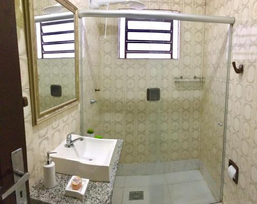新汉堡市Nossa Casa Novo Hamburgo的一间带水槽和玻璃淋浴的浴室