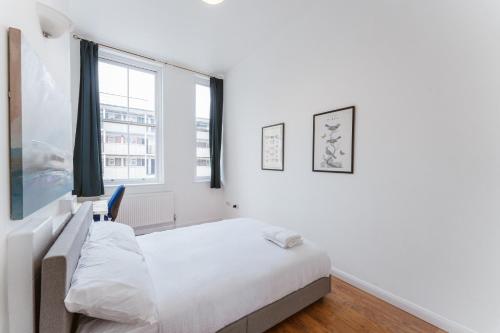 伦敦Bethnal Green beds to stay的白色的卧室设有床和窗户