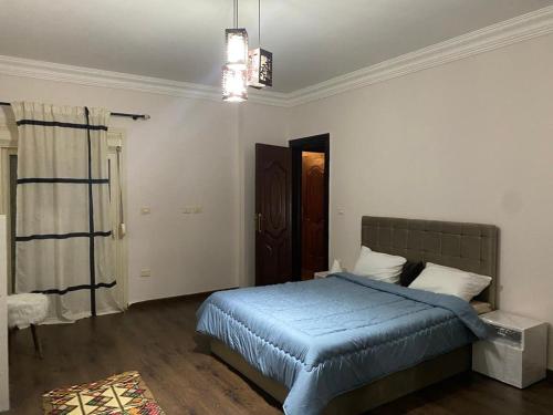 马迪纳特阿什舒鲁克Heliopolis Residence Shrouk city Cairo的一间卧室配有一张带蓝色棉被的床