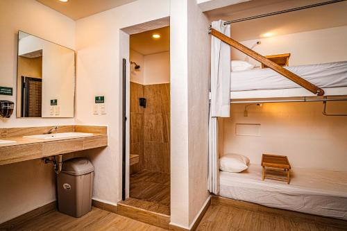 坎昆Nomads Party Hostel的一间带水槽和一张双层床的浴室