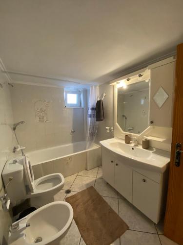 卡尔派尼西翁Sitara's House的浴室配有卫生间、盥洗盆和浴缸。
