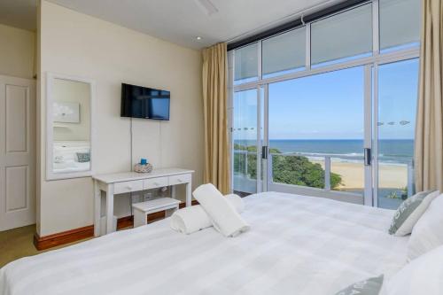 马盖特402@ColonialSands的卧室设有一张大白色床,享有海景