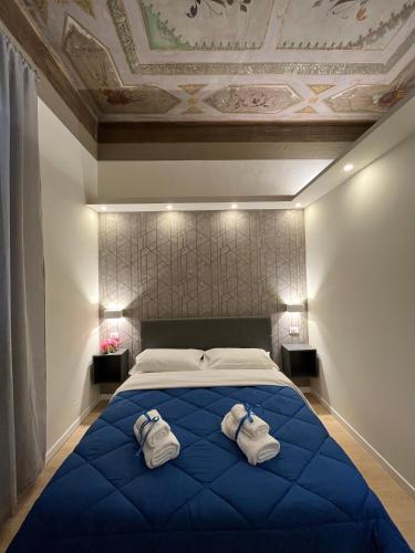 博洛尼亚La Suite Deluxe Rooms & Apartments的一间卧室配有一张大蓝色的床和毛巾