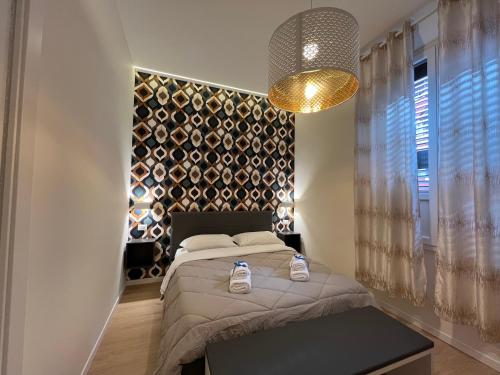 博洛尼亚La Suite Deluxe Rooms & Apartments的一间卧室配有一张床和一个吊灯