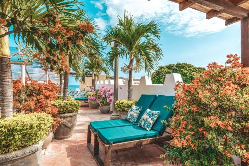 卡塔赫纳卡尔塔科萨酒店的一个带蓝色长椅和棕榈树的庭院