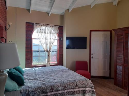 昂斯拉雷区Eden Crest Villa的一间卧室设有床、窗户和红色椅子