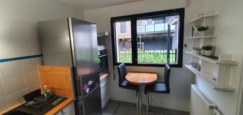 亚眠Hortillonne的厨房配有冰箱、桌子和窗户。