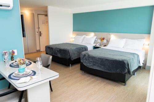 累西腓202 Flat Beira Mar Av Boa Viagem com Cozinha的酒店客房设有两张床和一张桌子。