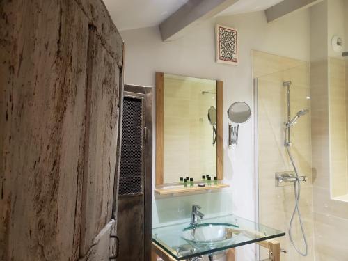 于泽斯La petite hostellerie的一间带玻璃水槽和淋浴的浴室
