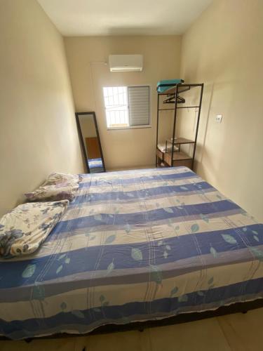 瓜拉廷格塔Apartamento Bela vista II的一间卧室配有一张带蓝色棉被的床