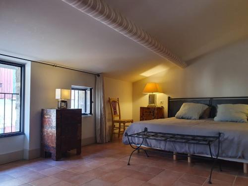 于泽斯La petite hostellerie的卧室配有床、椅子和窗户。