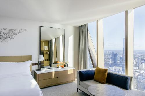 墨尔本The Ritz-Carlton, Melbourne的酒店客房,配有床、椅子和镜子