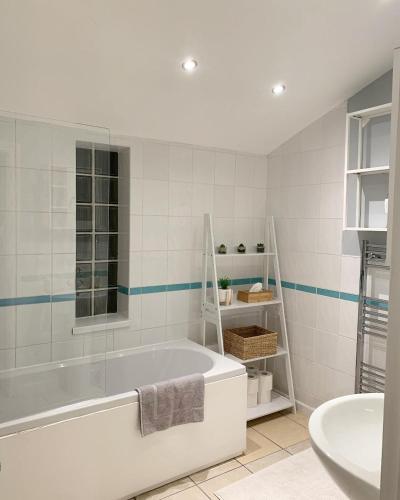 卡迪夫Cardiff Home的白色的浴室设有浴缸和水槽。