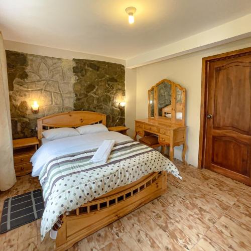 昆卡Quinta San Martín的一间卧室配有一张大床和镜子