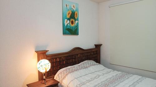 TlayecacConfortable casa de descanso para fin de semana的卧室配有一张床,墙上挂有绘画作品