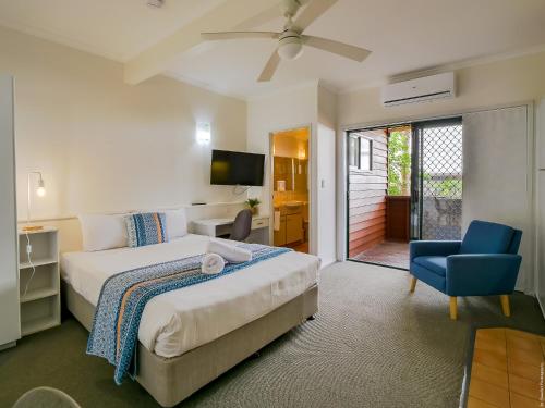 赫维湾船港一室公寓公寓式酒店和别墅的一间卧室配有一张床和一张蓝色椅子