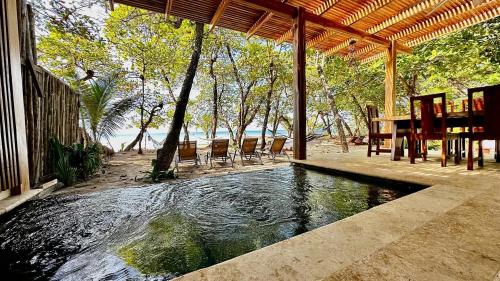 圣塔特蕾莎海滩Villas Paraiso Azul的一个带桌椅的庭院内的游泳池