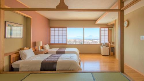 南小国町Senomoto Kogen Hotel的一间卧室设有两张床和大窗户